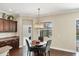 Cozy breakfast nook features a round table, comfortable chairs, and a modern chandelier with natural light from nearby window at 357 Marsh Creek Rd, Venice, FL 34292