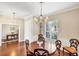 Bright dining room with hardwood floors, chandelier, wainscoting, and a view of the outdoors through a window at 357 Marsh Creek Rd, Venice, FL 34292