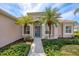 Inviting home featuring blue front door, lush landscaping, and stately palms at 357 Marsh Creek Rd, Venice, FL 34292