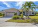 Charming single-Gathering home features a tile roof, well-manicured lawn, and lush tropical landscaping at 357 Marsh Creek Rd, Venice, FL 34292