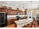 A kitchen featuring dark cabinets, stainless steel appliances, a breakfast bar with seating, and ample counter space at 357 Marsh Creek Rd, Venice, FL 34292