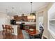 A spacious kitchen featuring dark cabinets, stainless steel appliances, a breakfast bar and a dining area at 357 Marsh Creek Rd, Venice, FL 34292