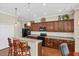 A well-equipped kitchen featuring dark cabinets, modern appliances, a breakfast bar, and ample counter space at 357 Marsh Creek Rd, Venice, FL 34292