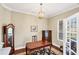 Traditional office with a large desk, grandfather clock, and hardwood floors offers a refined and productive workspace at 357 Marsh Creek Rd, Venice, FL 34292