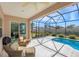 A screened patio with a ceiling fan and outdoor seating area by the pool and lanai at 357 Marsh Creek Rd, Venice, FL 34292
