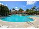 Community pool with water feature and access ladders surrounded by lounge chairs at 357 Marsh Creek Rd, Venice, FL 34292
