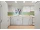 Kitchen with white cabinets, green tile, and stainless steel appliances at 407 Degas Dr, Nokomis, FL 34275