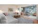 Living room with white sectional sofa, sunroom, wood floors, and mid century modern decor at 407 Degas Dr, Nokomis, FL 34275
