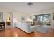 Living room with white sectional sofa, sunroom, wood floors, and mid century modern decor at 407 Degas Dr, Nokomis, FL 34275