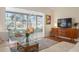Living room with white sectional sofa, sunroom, wood floors, and mid century modern decor at 407 Degas Dr, Nokomis, FL 34275