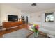Living room with white sectional sofa, wood floors, and mid century modern decor at 407 Degas Dr, Nokomis, FL 34275