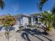 Gray house with attached garage,landscaped yard, and pink flowers at 4251 Oak Terrace Cir, Port Charlotte, FL 33953