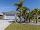 Gray house with attached garage,palm trees,landscaped yard at 4251 Oak Terrace Cir, Port Charlotte, FL 33953
