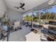 Bright screened porch with tiled floor, ceiling fan, and plenty of plants at 4251 Oak Terrace Cir, Port Charlotte, FL 33953