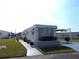 Mobile home with landscaped lawn, driveway, and carport at 426 Boxwood Dr, Venice, FL 34285