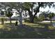Mature trees and manicured lawn create a welcoming curb appeal at 451 Home Park Rd, Venice, FL 34285