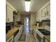 Long galley kitchen with light wood cabinets and appliances at 451 Home Park Rd, Venice, FL 34285