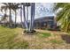 Spacious backyard with a covered patio, lush landscaping, and palm trees at 4621 Gaeta Dr, Venice, FL 34293
