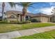 Tan house with tile roof, palm tree, landscaped yard, and driveway at 4621 Gaeta Dr, Venice, FL 34293
