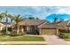 Tan house with tile roof, palm trees, and landscaped yard at 4621 Gaeta Dr, Venice, FL 34293