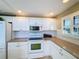 White kitchen with granite countertops and stove top at 500 Park S Blvd # 7, Venice, FL 34285