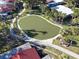 Community putting green with paved pathway, surrounded by palm trees at 500 Park S Blvd # 7, Venice, FL 34285