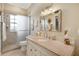 Bright bathroom with granite countertop, decorative mirror, and walk-in shower with glass enclosure at 522 Fallbrook Dr, Venice, FL 34292