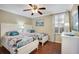 Cozy bedroom showcasing two twin beds, hardwood floors, and plenty of natural light at 522 Fallbrook Dr, Venice, FL 34292