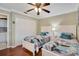 Comfortable bedroom with wood floors, ceiling fan, and ample closet space at 522 Fallbrook Dr, Venice, FL 34292