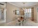 Elegant dining room features a chandelier, wooden table, seating for six and bright, natural light at 522 Fallbrook Dr, Venice, FL 34292