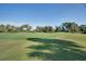 Manicured golf course with lush green grass, mature trees, and a clear blue sky on a sunny day at 522 Fallbrook Dr, Venice, FL 34292