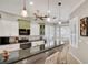 Modern kitchen with stainless steel appliances, granite countertops, tile backsplash, and eat-in breakfast bar at 522 Fallbrook Dr, Venice, FL 34292