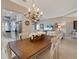Open concept living room and dining area showcases a chandelier, tile floors, and view to the kitchen at 522 Fallbrook Dr, Venice, FL 34292