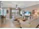 Comfortable living room with tile floors, neutral paint, sliding glass door and view to outdoor landscape at 522 Fallbrook Dr, Venice, FL 34292