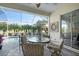 The screened-in patio is set up for outdoor dining with scenic views of the backyard swimming pool at 522 Fallbrook Dr, Venice, FL 34292