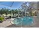 A beautiful screened-in pool is surrounded by brick decking, offering a relaxing retreat in a tropical setting at 522 Fallbrook Dr, Venice, FL 34292