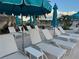 Relaxing pool deck with lounge chairs and umbrellas perfect for enjoying sunny days at 522 Fallbrook Dr, Venice, FL 34292