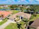 Stunning aerial view of home with tile roof, lake view, and lush landscaping at 523 Park Estates Sq, Venice, FL 34293