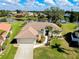 An aerial view of a single-story home with tile roof, landscaping, and lake view at 523 Park Estates Sq, Venice, FL 34293
