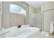 Bathroom featuring a large bathtub, a separate shower, and a frosted window at 523 Park Estates Sq, Venice, FL 34293
