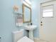 Charming powder room with a pedestal sink and decorative mirror and lighting at 523 Park Estates Sq, Venice, FL 34293