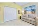 Cozy bedroom area with a comfortable sofa, neutral tile, and a closet for ample storage space at 523 Park Estates Sq, Venice, FL 34293