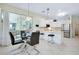 Bright dining area with a glass table, sliding glass doors and an open kitchen with stainless steel appliances at 523 Park Estates Sq, Venice, FL 34293