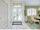 Entry foyer with white tile floor, closet, and view of the dining room with shuttered window at 523 Park Estates Sq, Venice, FL 34293