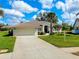 Inviting single-story home featuring a tile roof, two-car garage, and well-kept lawn at 523 Park Estates Sq, Venice, FL 34293
