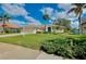 Well-manicured front yard with lush landscaping, palm trees and a two-car garage at 523 Park Estates Sq, Venice, FL 34293