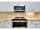 Close up of the kitchen's stainless steel appliances and a white tile backsplash at 523 Park Estates Sq, Venice, FL 34293