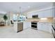 Modern kitchen with stainless steel appliances, white cabinets, and a breakfast bar at 523 Park Estates Sq, Venice, FL 34293