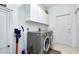 Bright laundry room featuring a washer, dryer, and storage cabinets at 523 Park Estates Sq, Venice, FL 34293