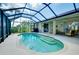 Enclosed screened pool with sun-shelf and in-ground spa, surrounded by patio and landscaping at 523 Park Estates Sq, Venice, FL 34293